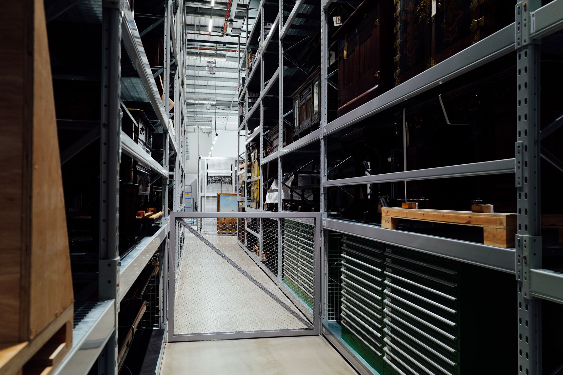 Metal storage racks lining a gated aisle inside a clean industrial warehouse interior